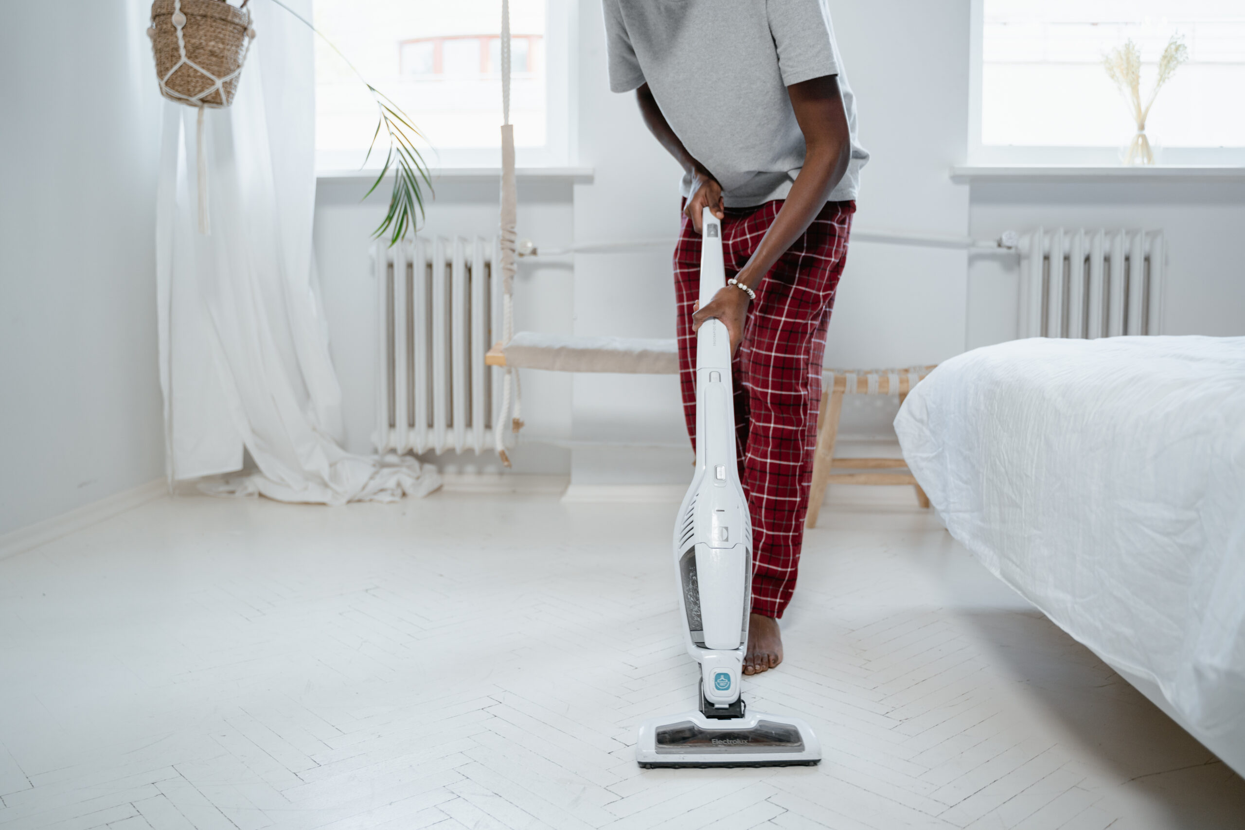 Barefoot man using vacuum cleaner